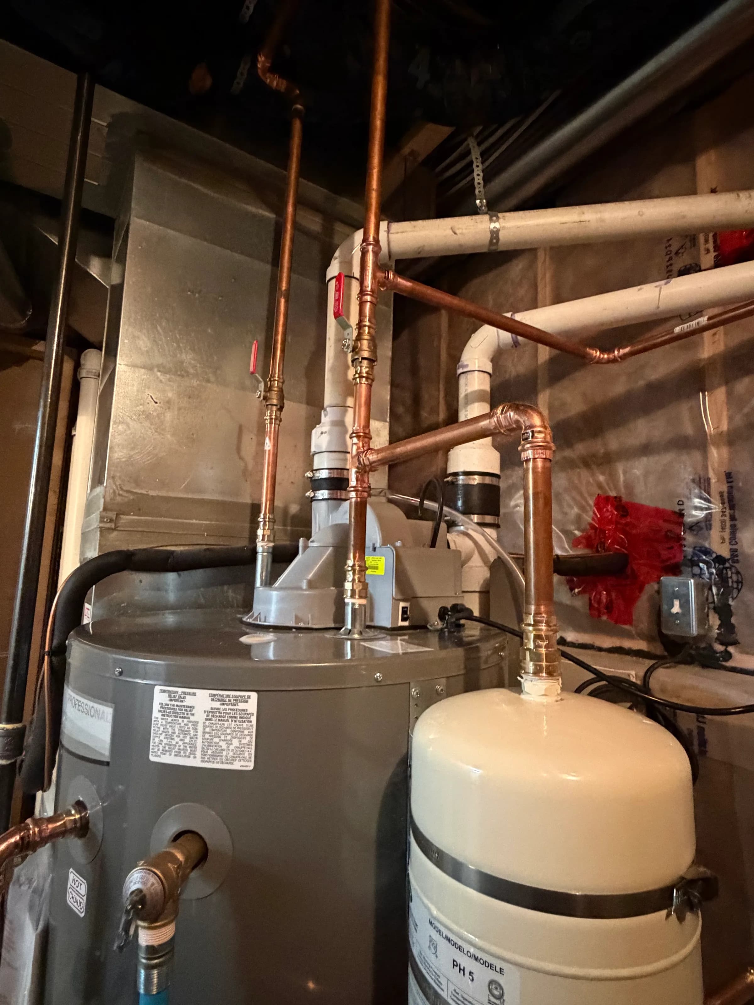 Hydronic heating mechanical room installation with copper pipe runs and expansion tank