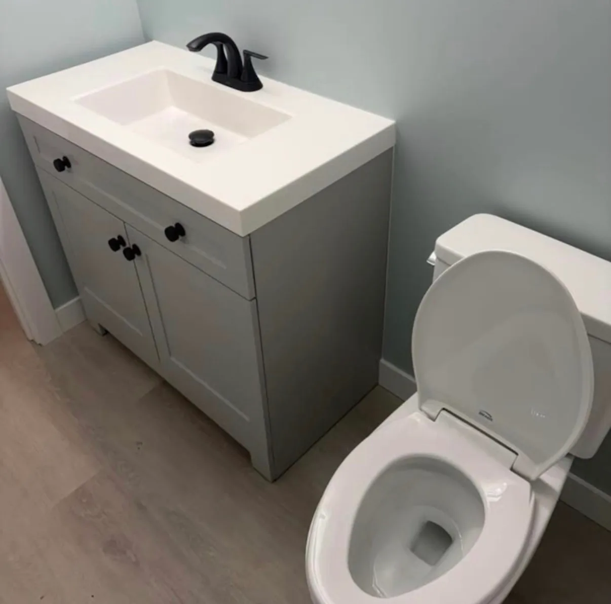Finished bathroom vanity and toilet installation by First Class Mechanical