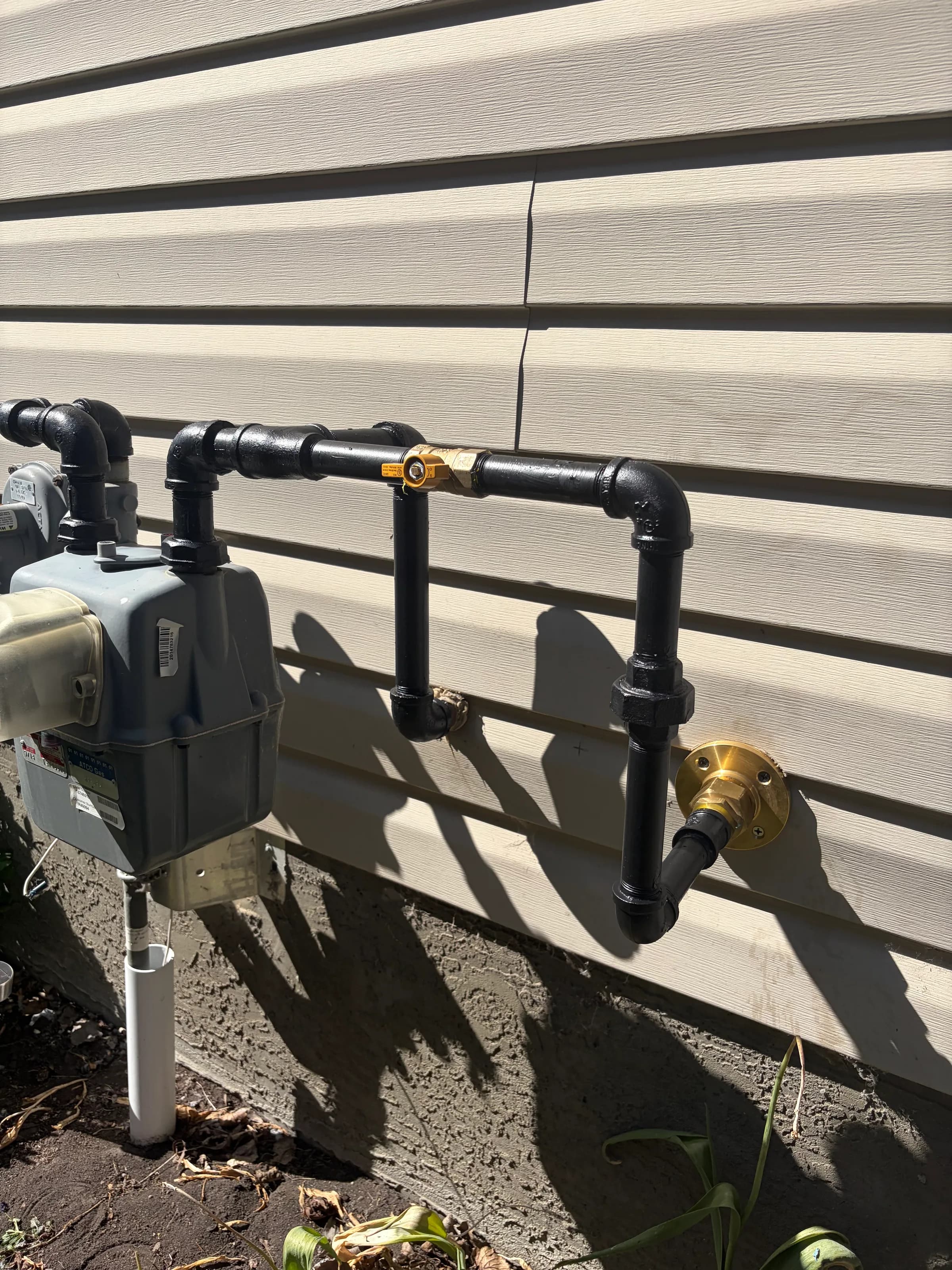 Exterior gas line and meter installation with black iron pipe