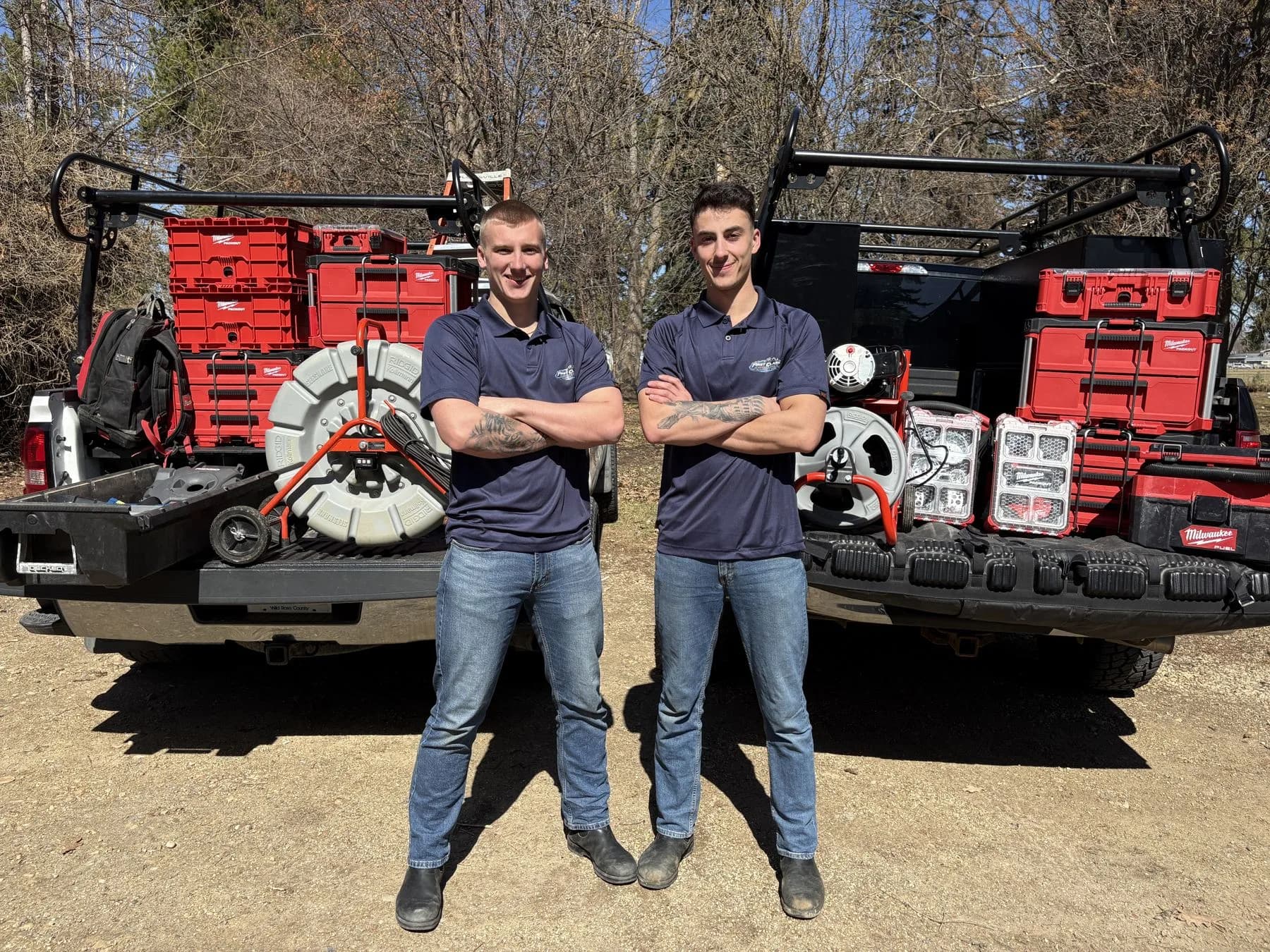 First Class Mechanical plumbers standing with drain cleaning reels and tool cases loaded in the truck