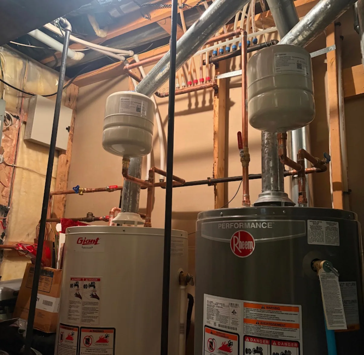 Old and new water heater side by side during a First Class Mechanical replacement job