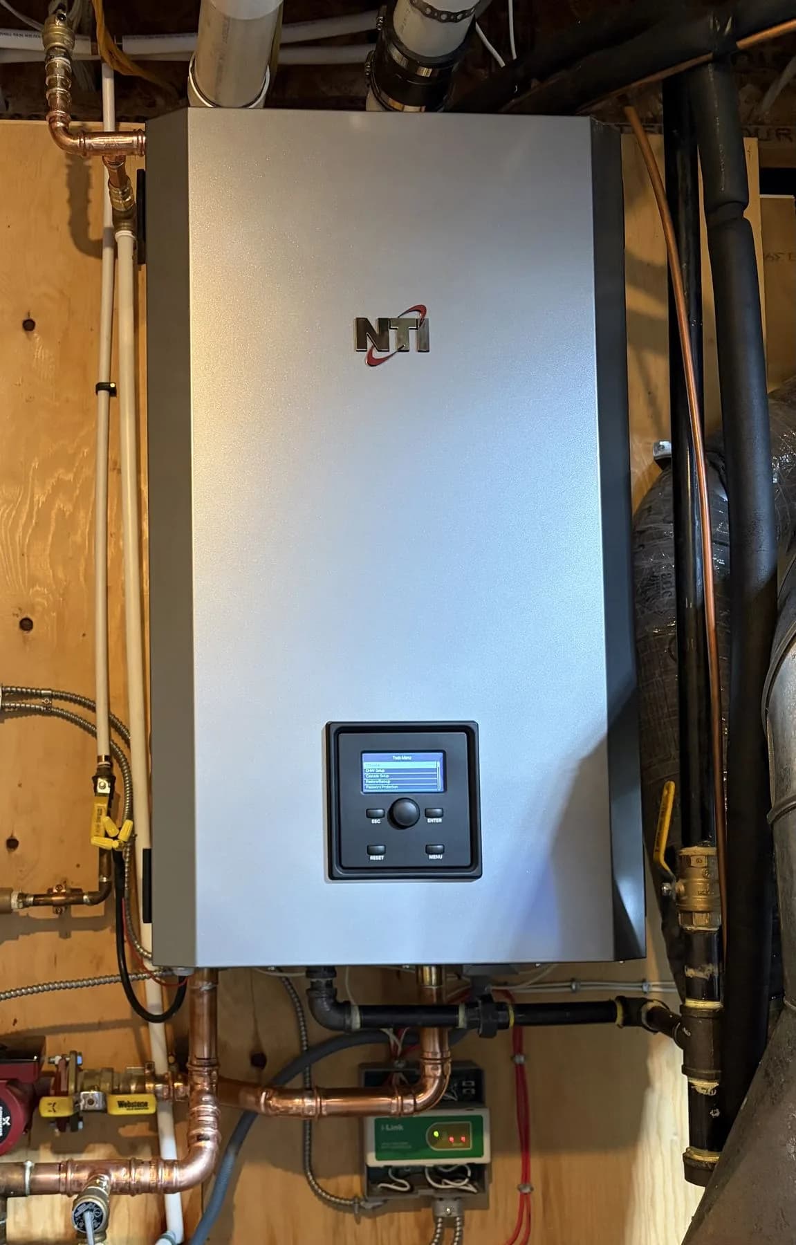 Wall-mounted condensing boiler installation with copper piping and venting